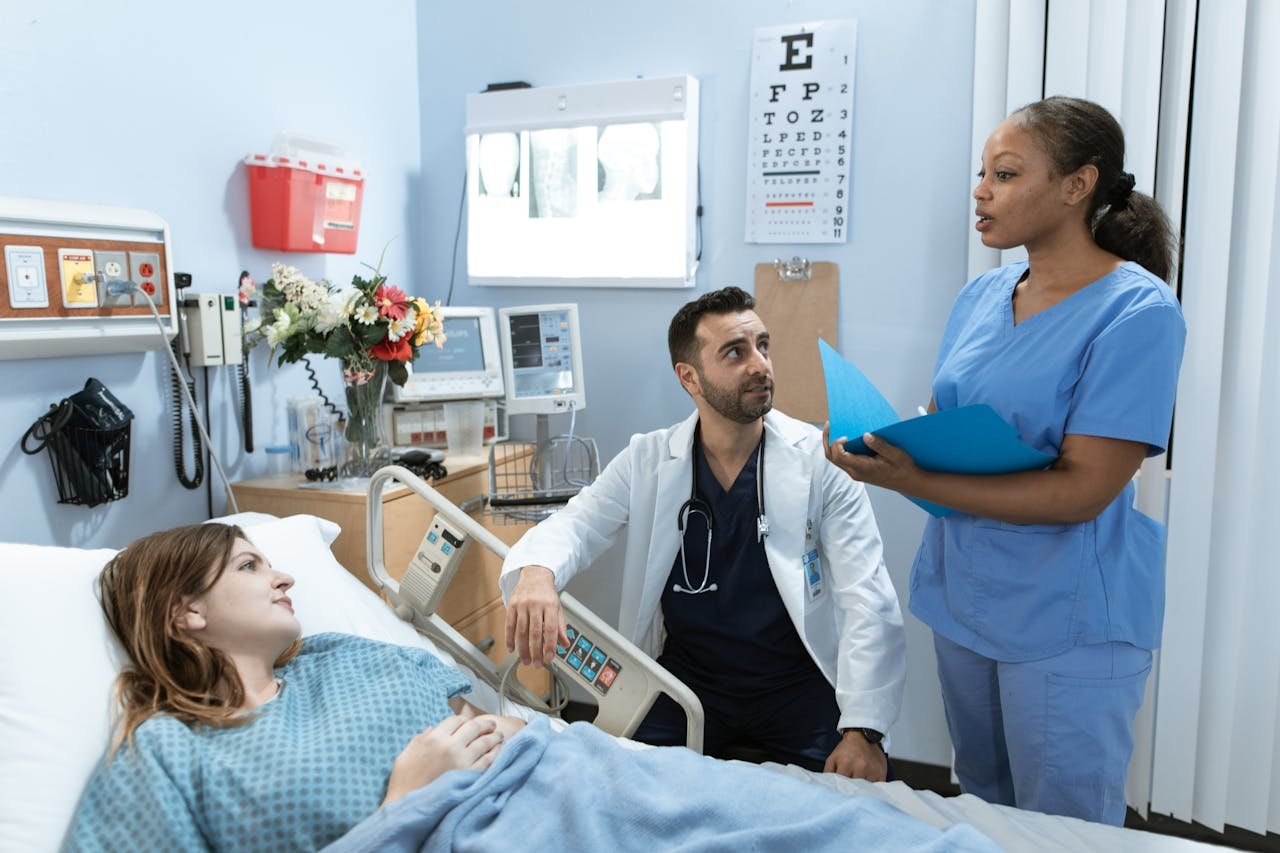 Doctors and nurse discussing patients treatment in a hospital room.